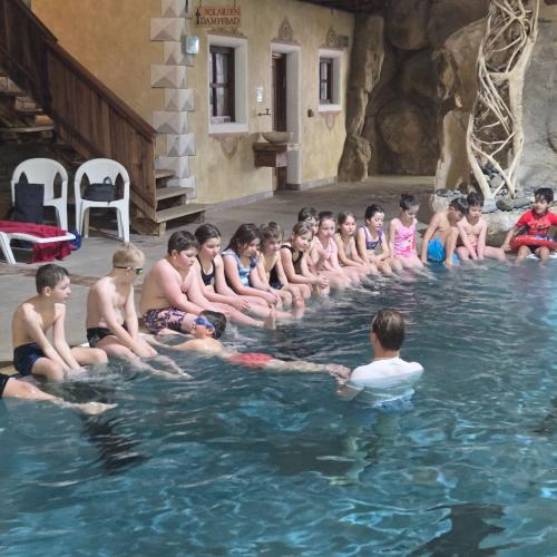 Kinder sitzen am Beckenrand