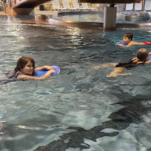 Schwimmende Kinder mit Schwimmbrett