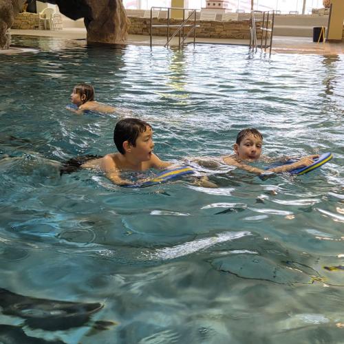 Schwimmende Kinder mit Schwimmbrett