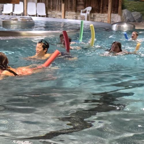 Schwimmende Kinder mit Schwimmnudel