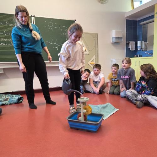 Kind mit Gießkanne und Wasserrad