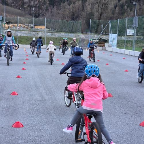 Kinder fahren im Abstand hintereinander her.
