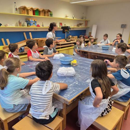 Kinder verfolgen die ersten Anweisungen zur Tonarbeit.